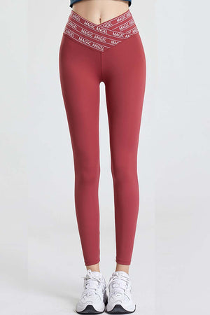 Red active leggings with a V-waistband and white logo band detail.