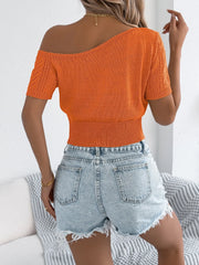 Orange open-knit asymmetric crop top with short sleeves and textured detail.