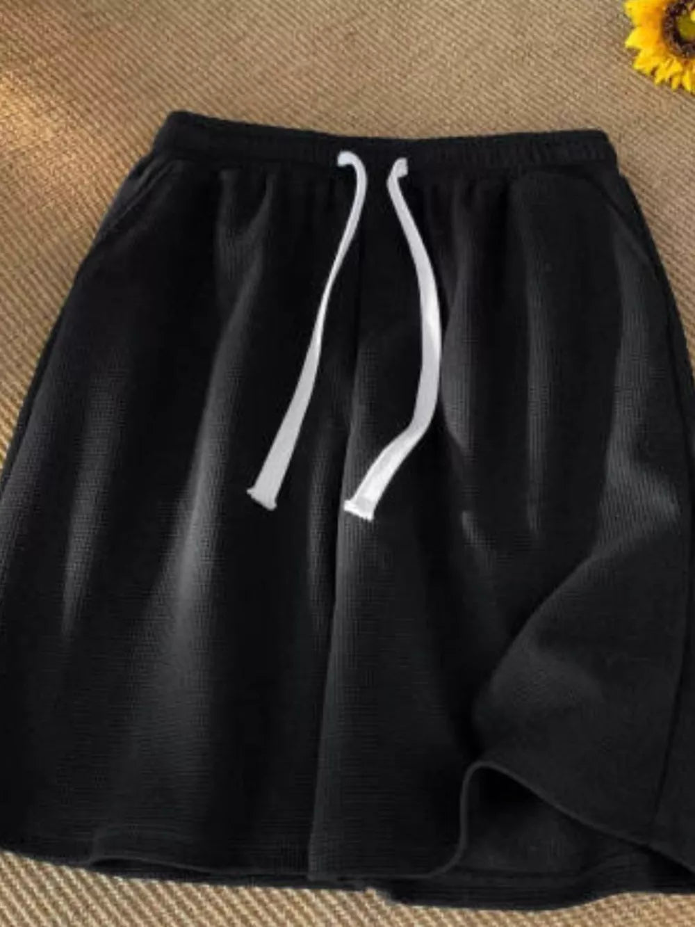 Black waffle knit boxer shorts with white drawstring and pockets