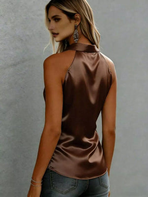 Luxurious satin sleeveless button-up shirt in dark brown with a curved hem.
