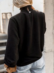 Black textured puff sleeve blouse with smocked neck and button detail