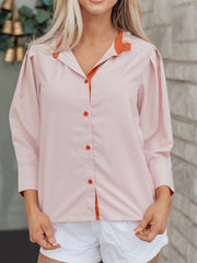 Maternity shirt with orange frilled collar, orange buttons, and pink and white stripes.