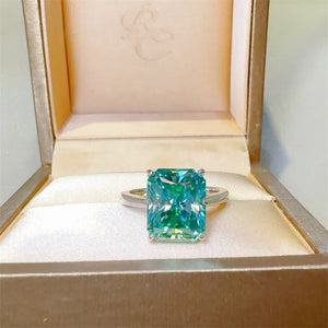 Emerald cut moissanite ring in silver with architectural design and bright brilliance.