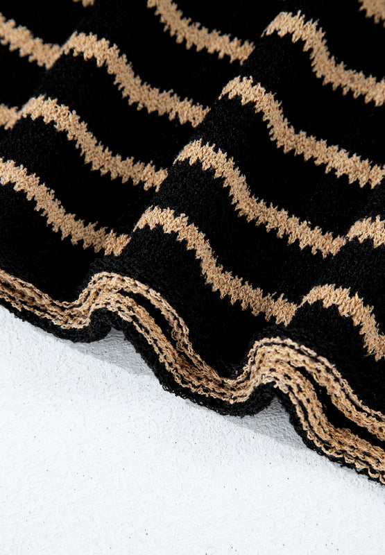 Black knit jumper with horizontal beige zigzag stripes and a textured hem.