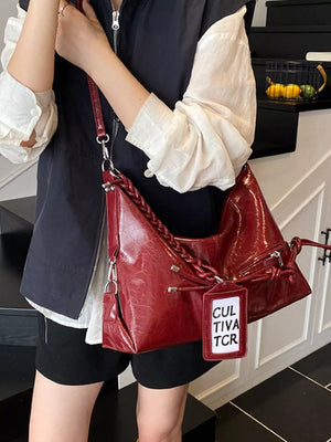 Red shoulder bag with braided strap and tag detail