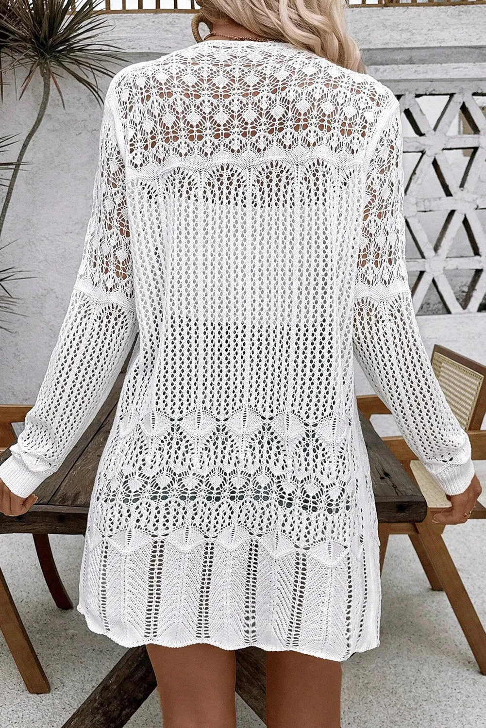 White openwork crochet duster cardigan with intricate lace patterns and long sleeves.