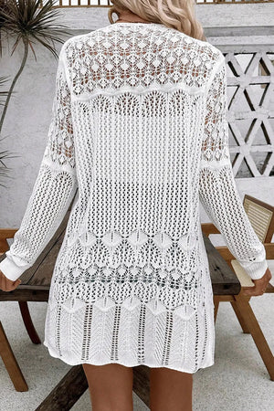 White openwork crochet duster cardigan with intricate lace patterns and long sleeves.