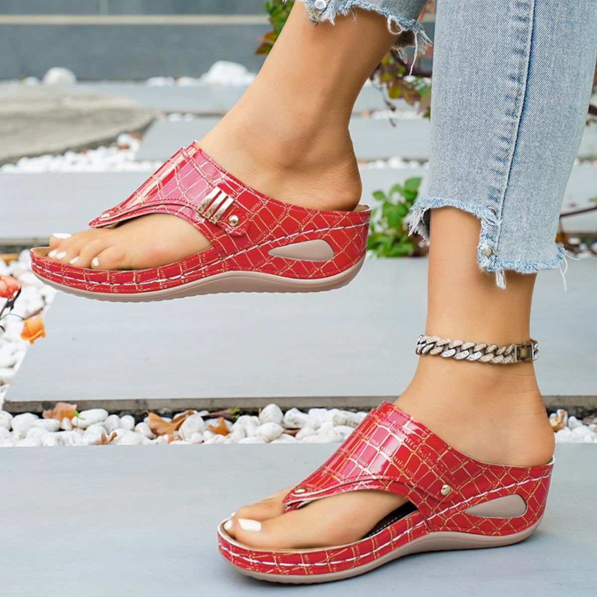 Red crocodile-embossed wedge thong sandals with gold buckle detail.