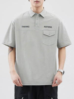 Light gray polo shirt with button detail, chest pocket, and text graphic.