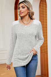 Light gray ribbed knit top with eyelet shoulder detail and long sleeves.