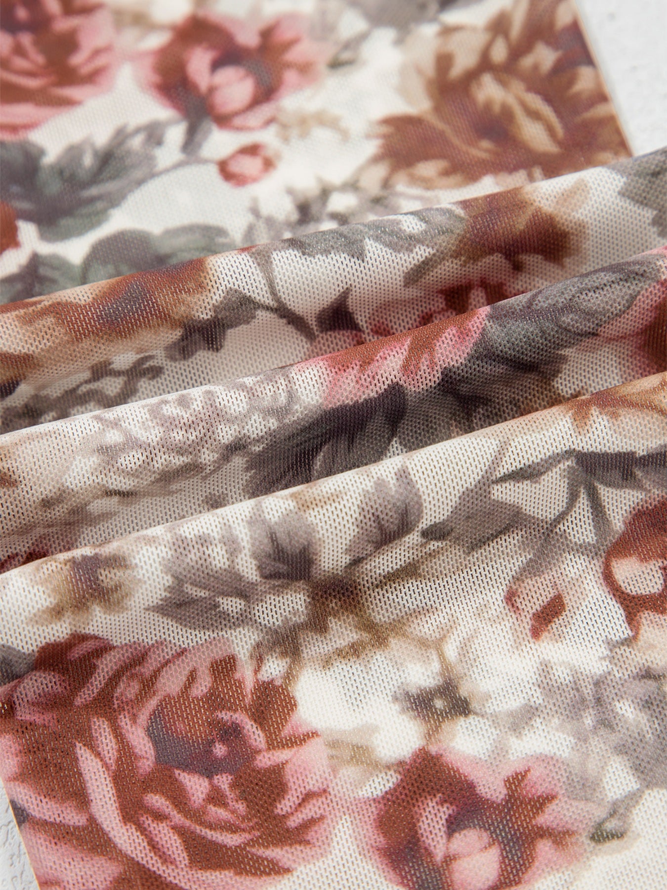 Charming floral mesh blouse with muted pink and brown roses, showing fabric texture.
