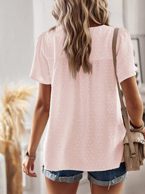 Blush pink textured puff sleeve blouse with dotted pattern and short sleeves.