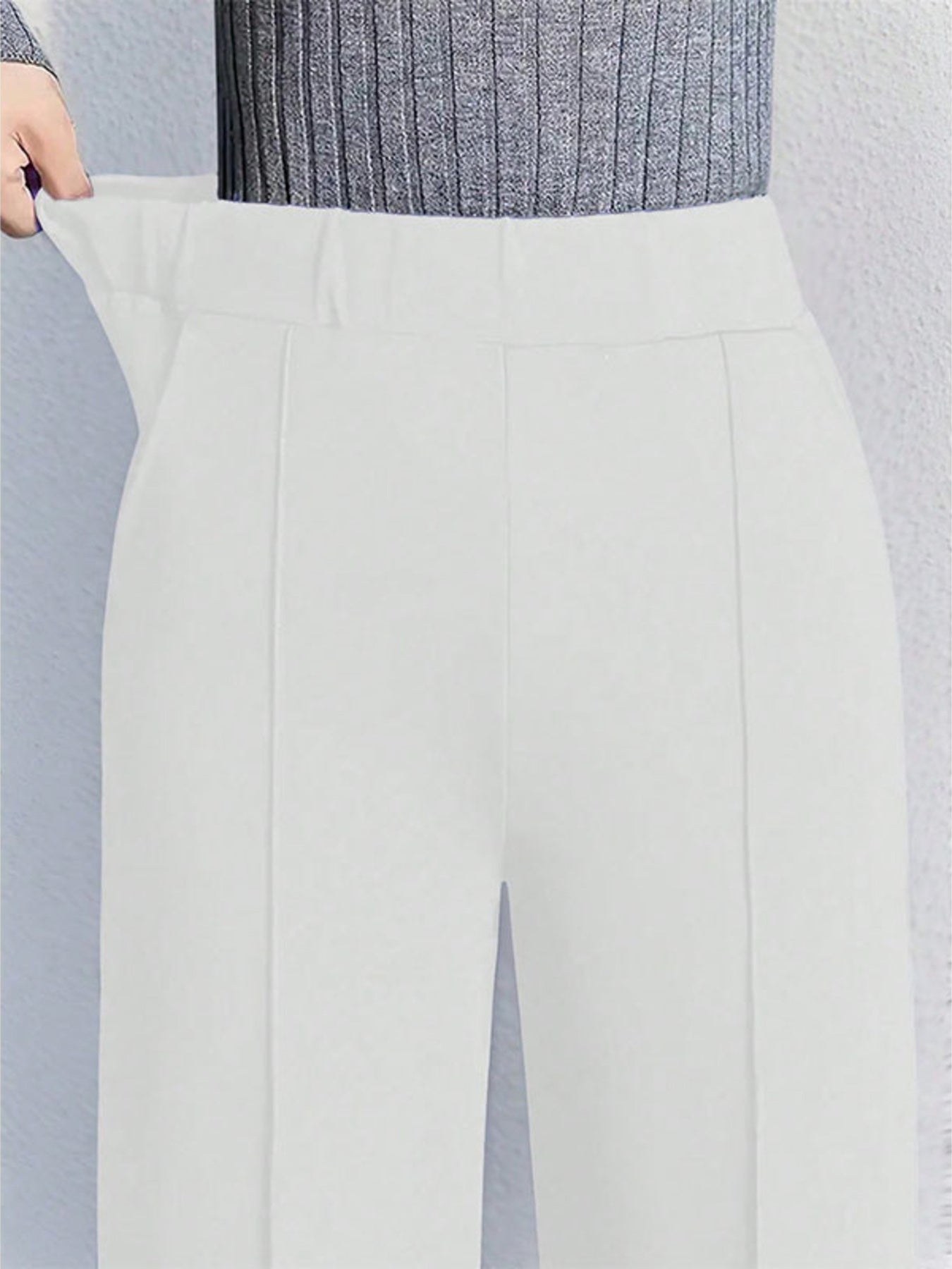 White high-waisted wide leg cotton trousers with pockets and a comfortable fit.