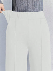White high-waisted wide leg cotton trousers with pockets and a comfortable fit.
