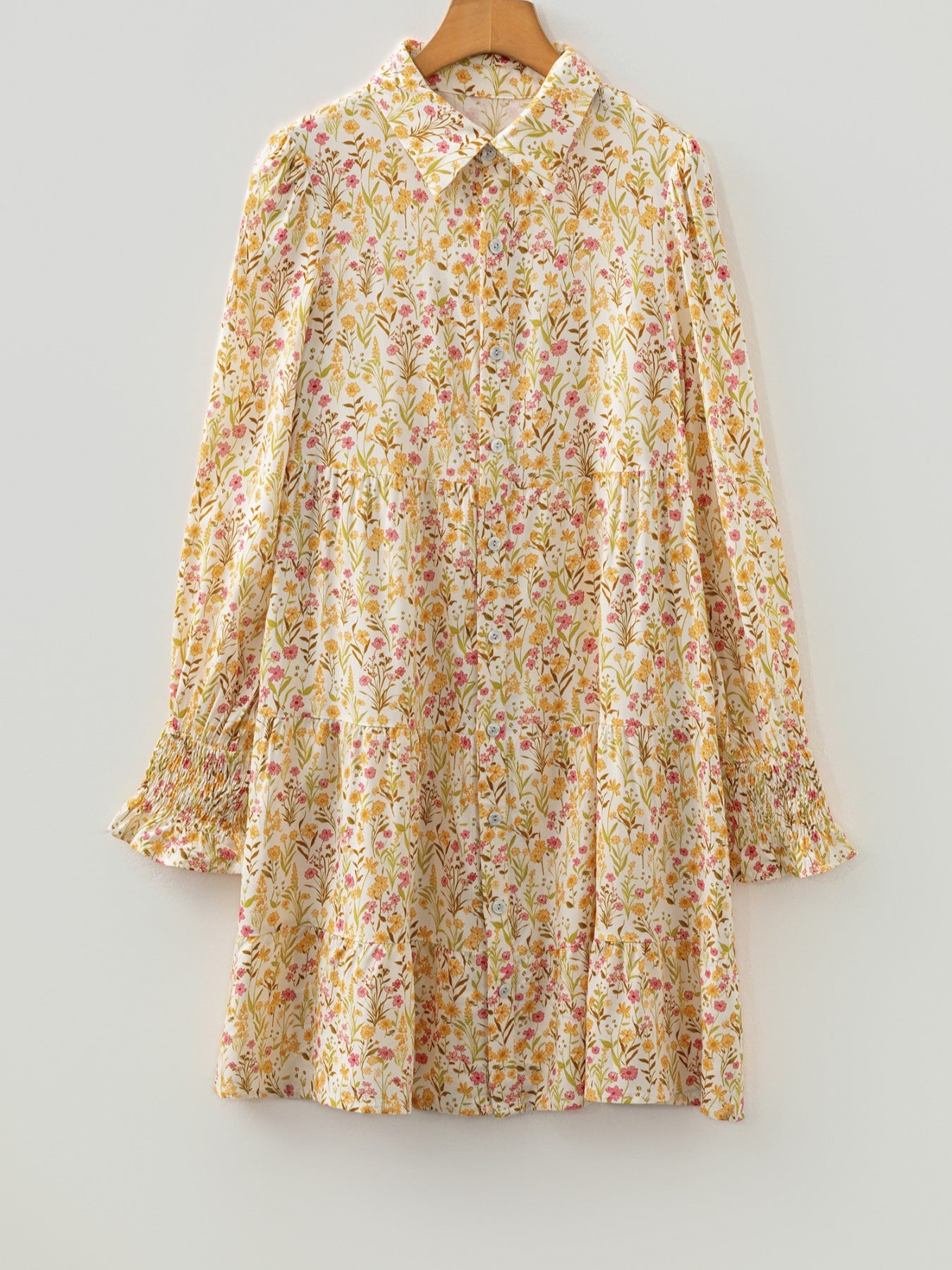 Floral print button-down shirt dress with tiered skirt and smocked cuffs.