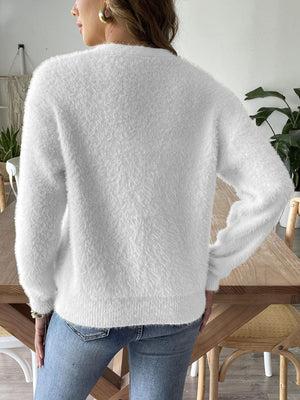 White plush button-down cardigan with pearl details, crew neck, long sleeves.