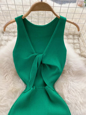 Emerald green ribbed knit midi dress with knot-back detail and cutout.