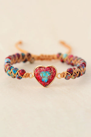 Multicolor beaded bracelet with a red and blue heart stone centerpiece and gold accents.