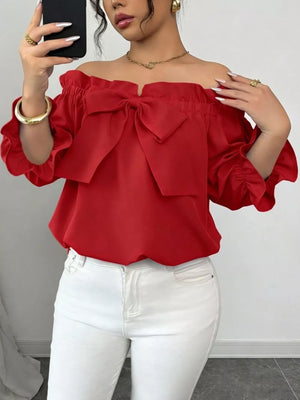 Red off-the-shoulder blouse with ruffled bow detail and puff sleeves.