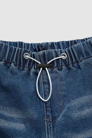 Medium wash cotton palazzo jeans with elastic waist and drawstring detail