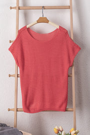 Open-knit dolman sleeve top in watermelon pink acrylic with boat neckline.