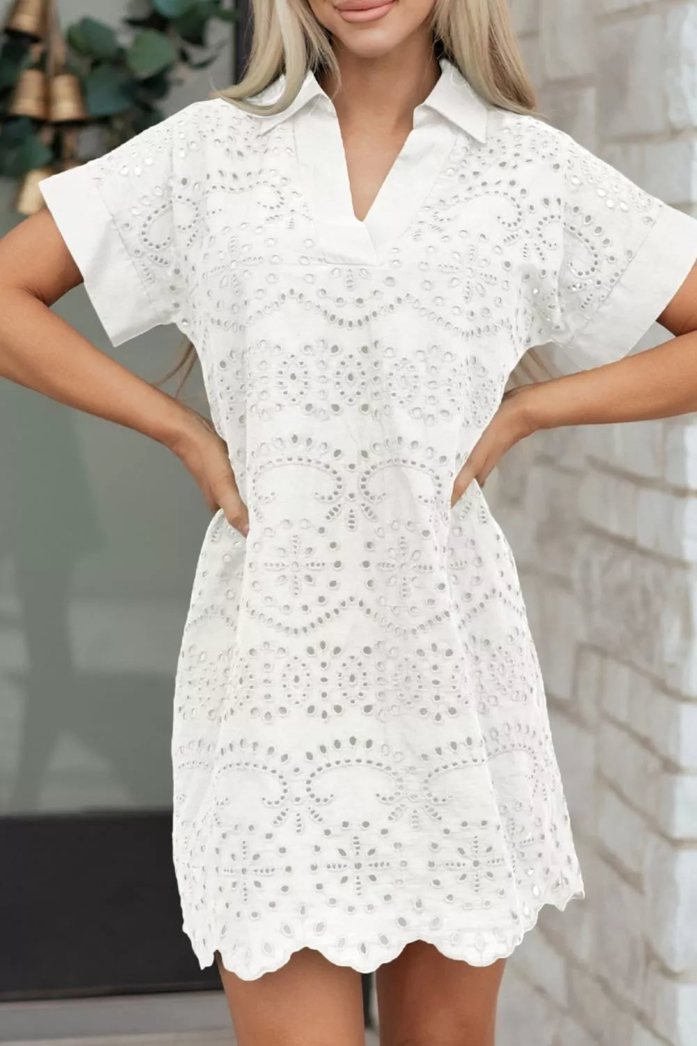 White eyelet embroidered cotton mini dress with short sleeves and a collared V-neck.