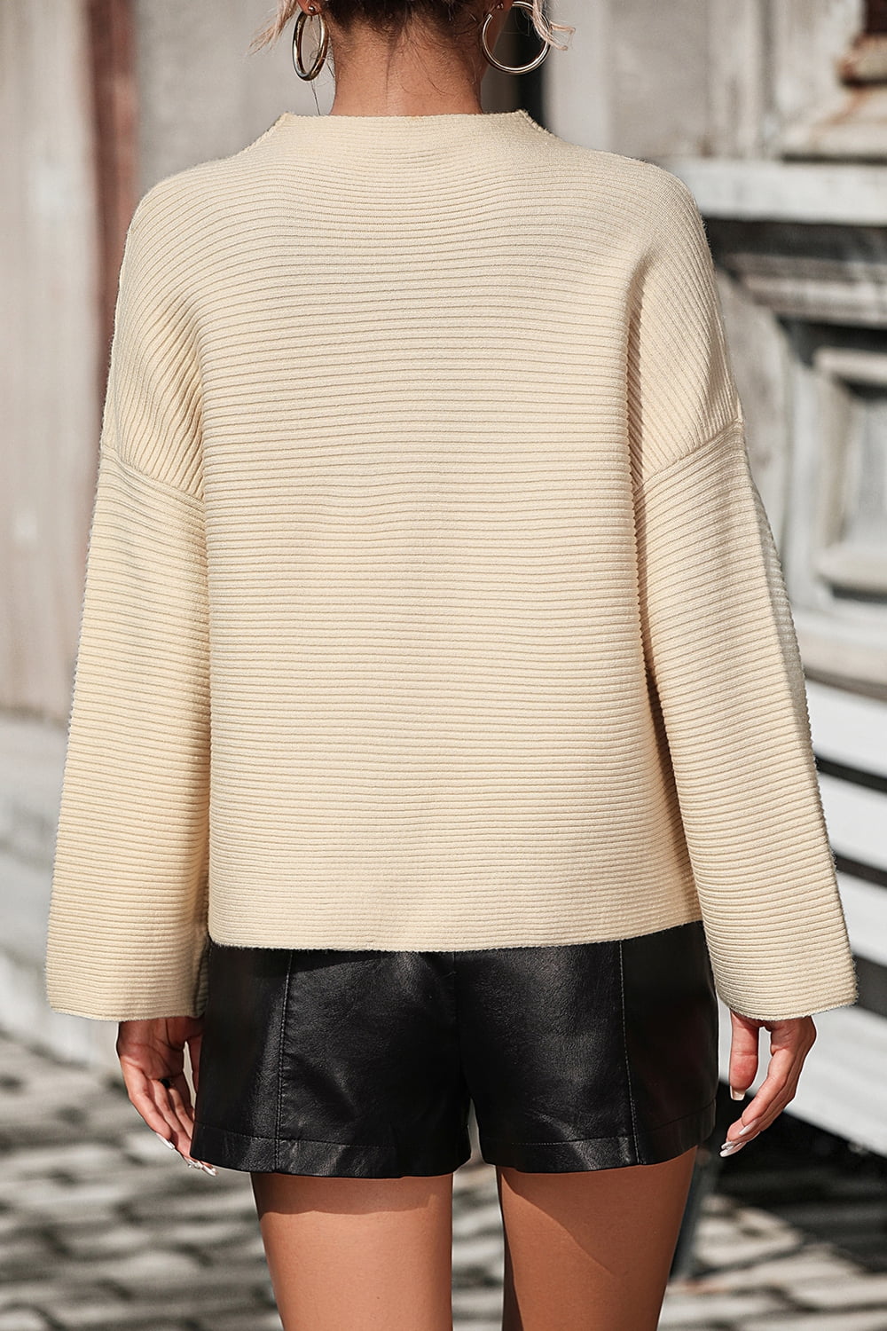 Tan ribbed mock neck sweater with volume sleeves and a relaxed fit.