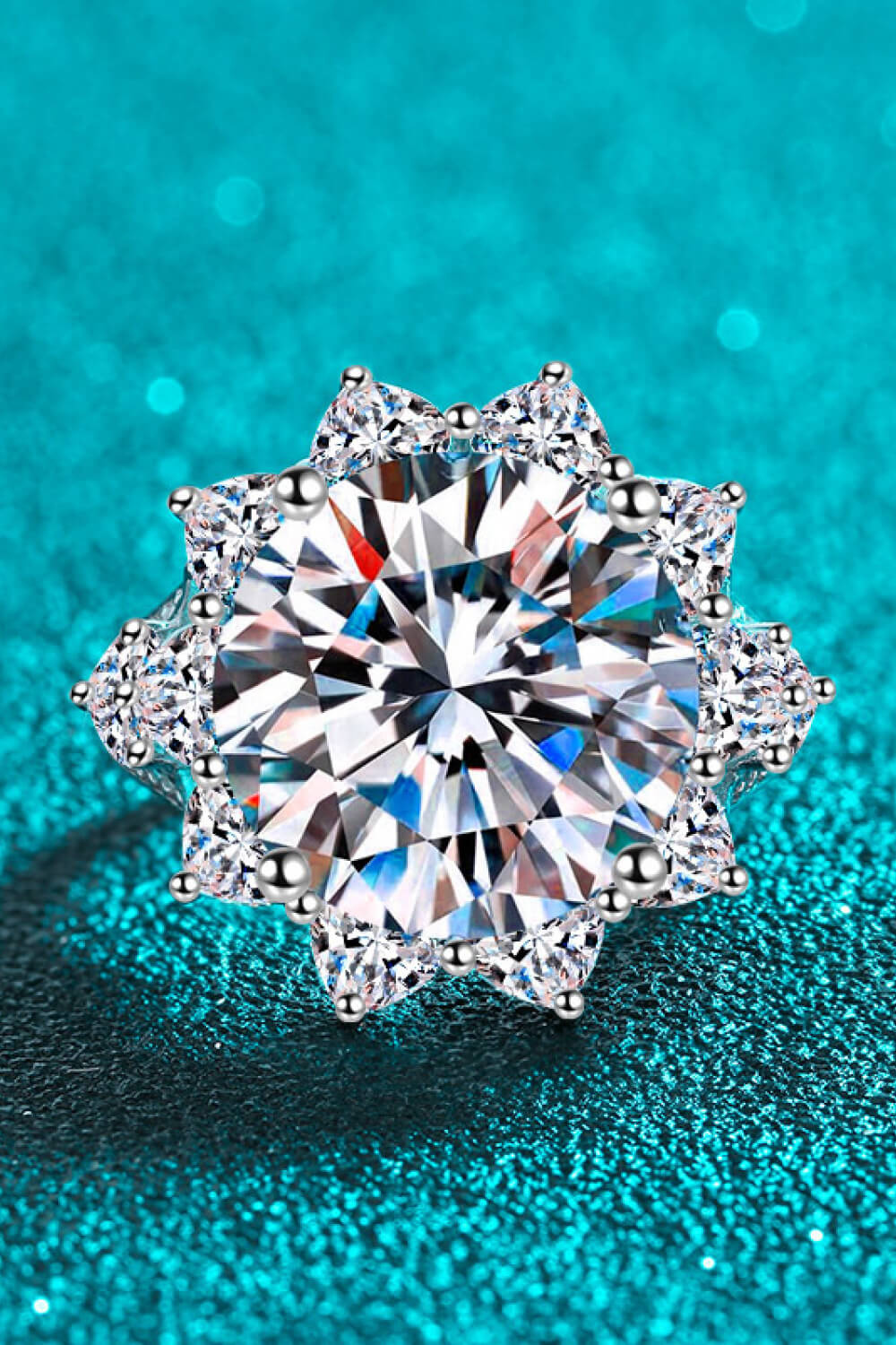 Silver moissanite cocktail ring with starburst halo and brilliant center stone.