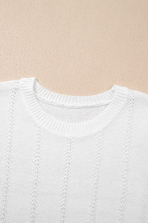 White eyelet knit blouse with crew neck and puff sleeves.