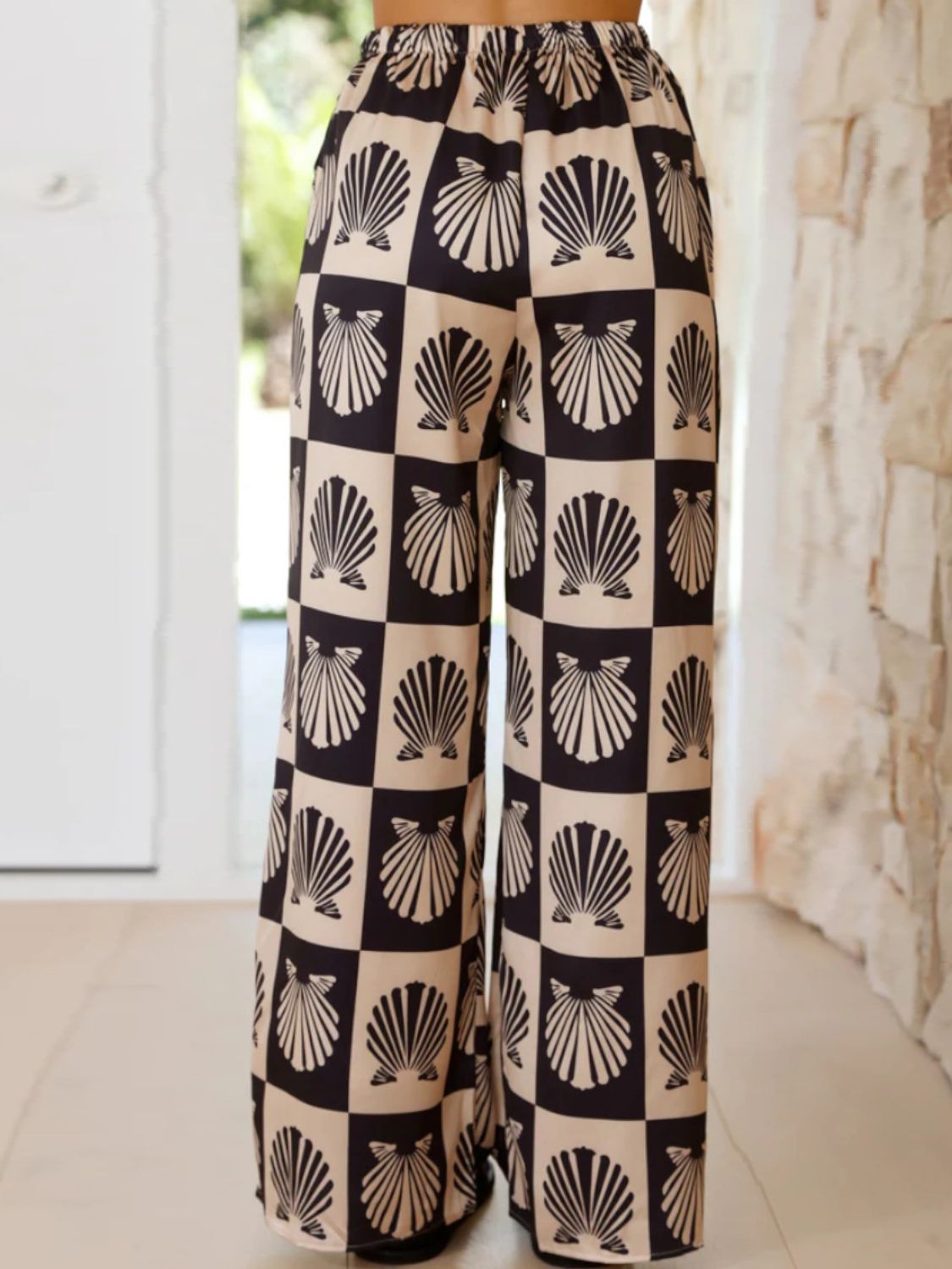 Black silk pajama pants with a shell print and checkered pattern.