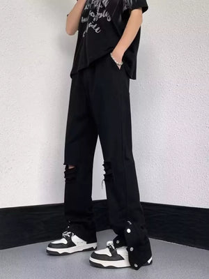 Black distressed loose-fit jeans with snap detail and adjustable hem
