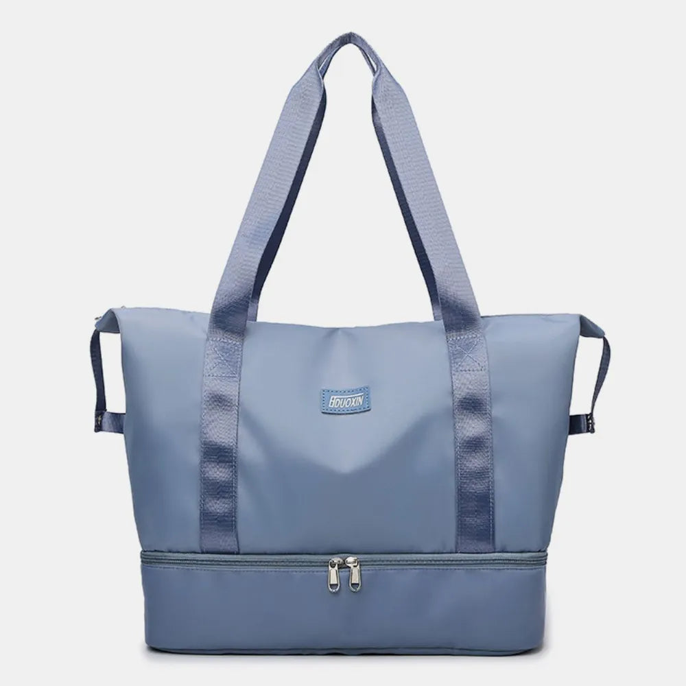 Dusty Blue dual-compartment travel tote with metallic trim and dual zippers.