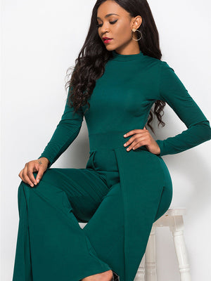Dark green high-waisted palazzo jumpsuit with slit front and long sleeves.
