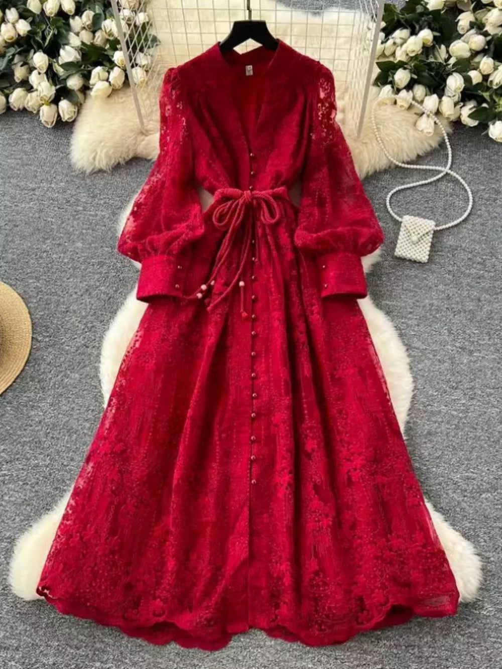 Red lace maxi dress with tie waist, button front, and balloon sleeves.