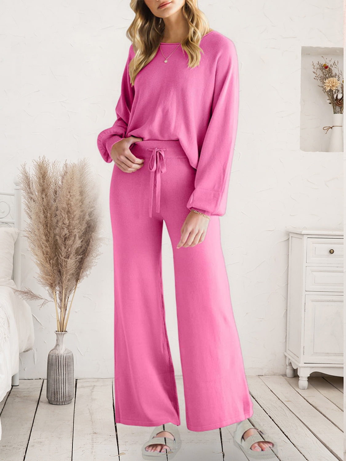 Pink acrylic loungewear set with wide-leg pants and long sleeves.