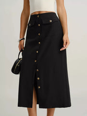 Black midi skirt with button front, flap pockets, and a front slit.