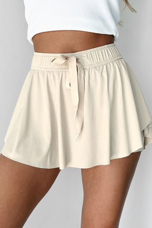 Beige ruffled skort with tie waist detail and elastic waistband.