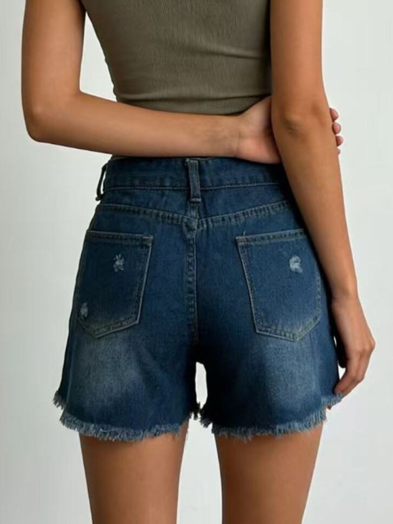 Dark blue denim shorts with frayed hem and distressed details.