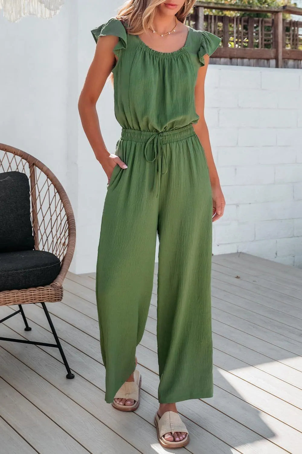 Matcha green textured drawstring palazzo jumpsuit with ruffle sleeves.