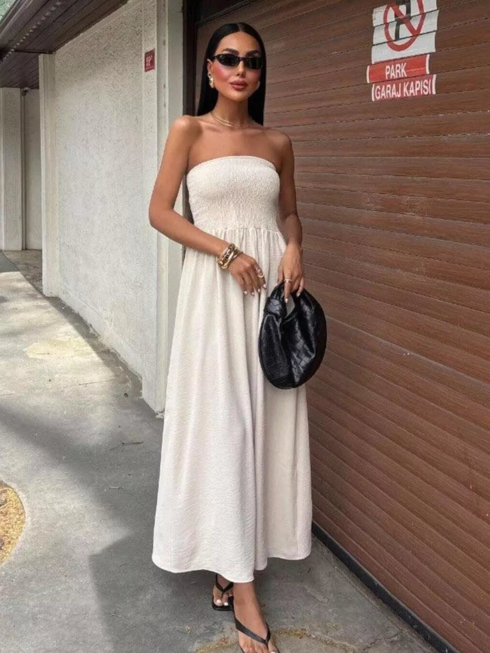 Beige smocked bodice relaxed maxi dress with a strapless neckline and textured fabric.