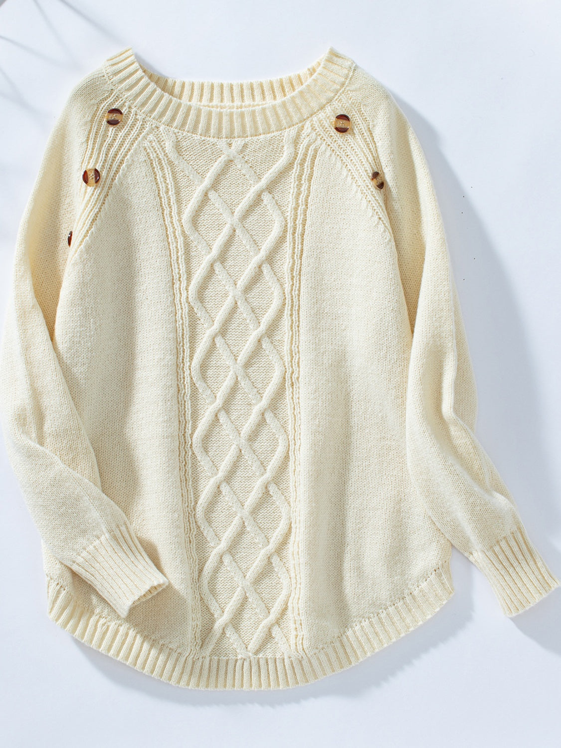 Cream cable knit sweater with button shoulder detail and crew neck.
