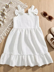 White baby dress with bowknot straps, textured fabric, and ruffle hem.