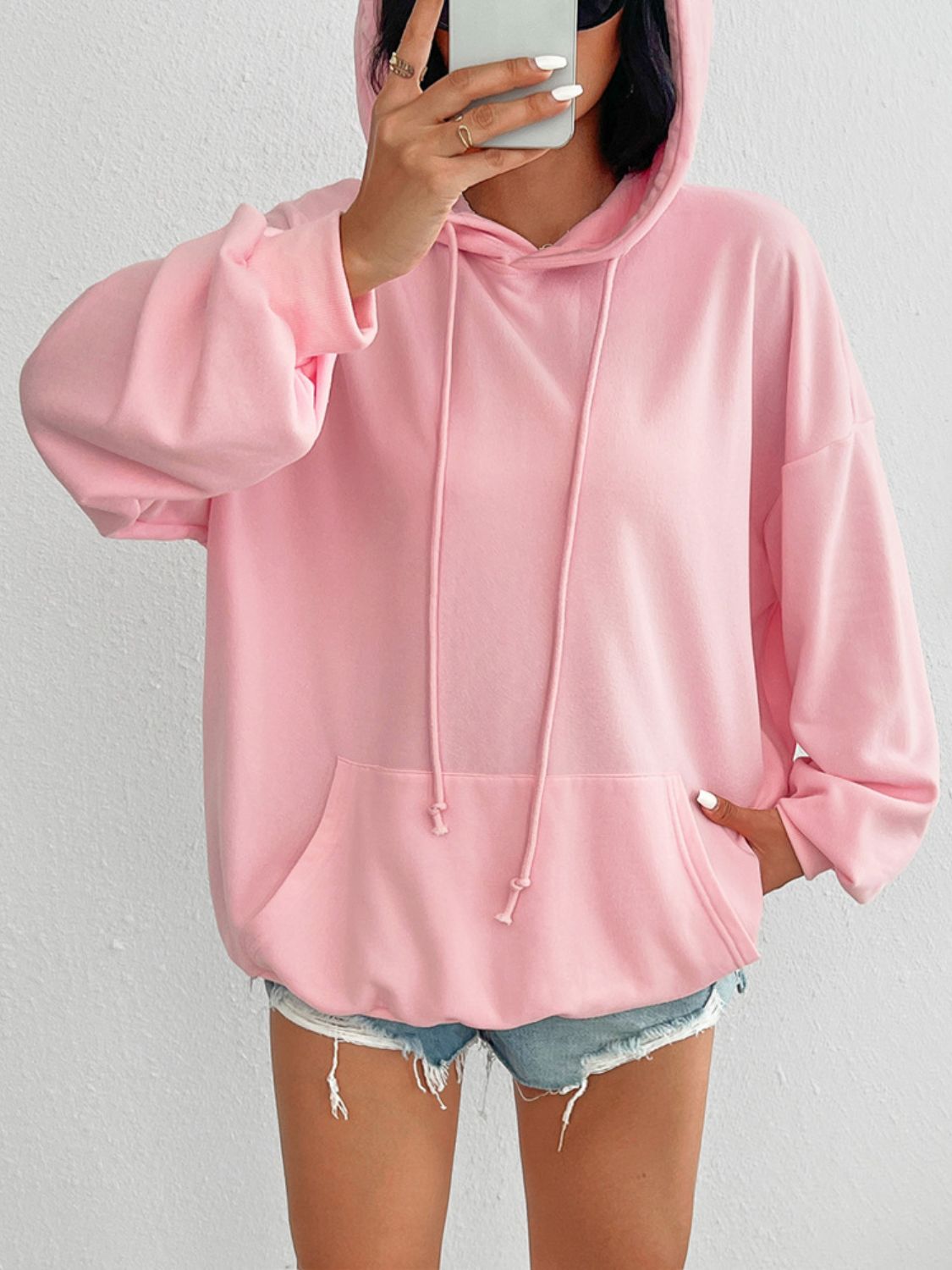 Oversized blush pink hoodie with drawstring detail and front pocket.
