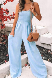 Light blue smocked bodice palazzo jumpsuit with wide legs and pockets.