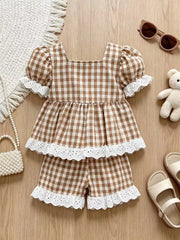 Brown gingham baby set with square neck, puff sleeves, and eyelet ruffle trim.