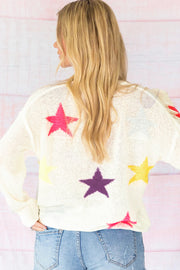 White knit sweater with colorful starburst pattern, long sleeves, casual fit.