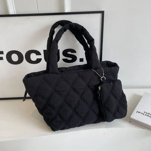 Black quilted tote bag with diamond pattern and matching coin purse detail.