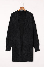 Black textured acrylic open cardigan with puff sleeves and a waffle knit.