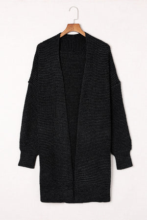 Black textured acrylic open cardigan with puff sleeves and a waffle knit.