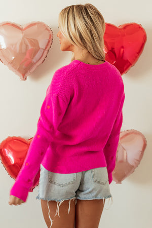 Pink ribbed crewneck sweater with allover heart embroidery, long sleeves.